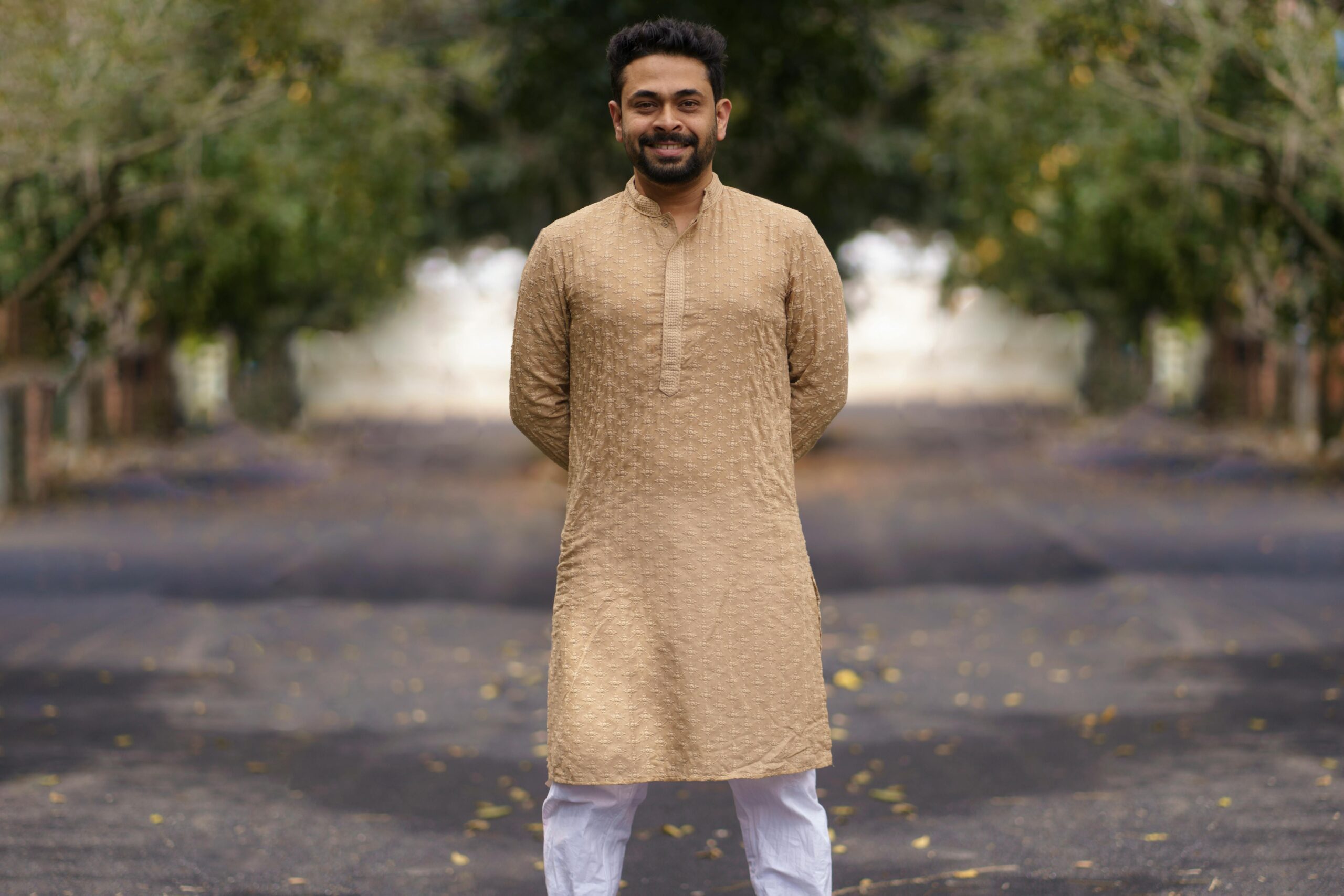 Portrait of a smiling man in a traditional kurta pyjama on a sunny day.